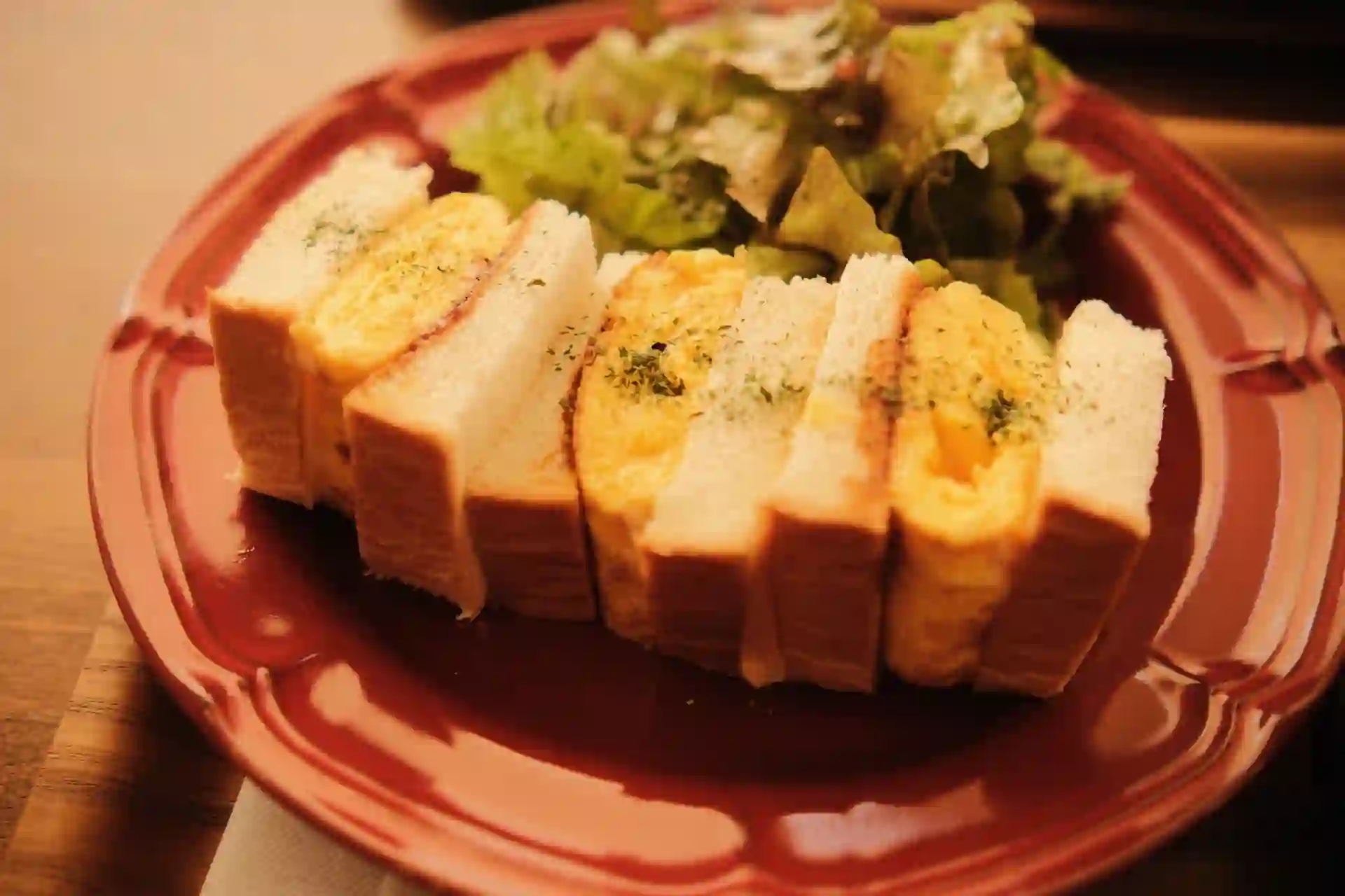A Japanese tamago sando (egg salad sandwich) cut in half, showing the soft egg filling