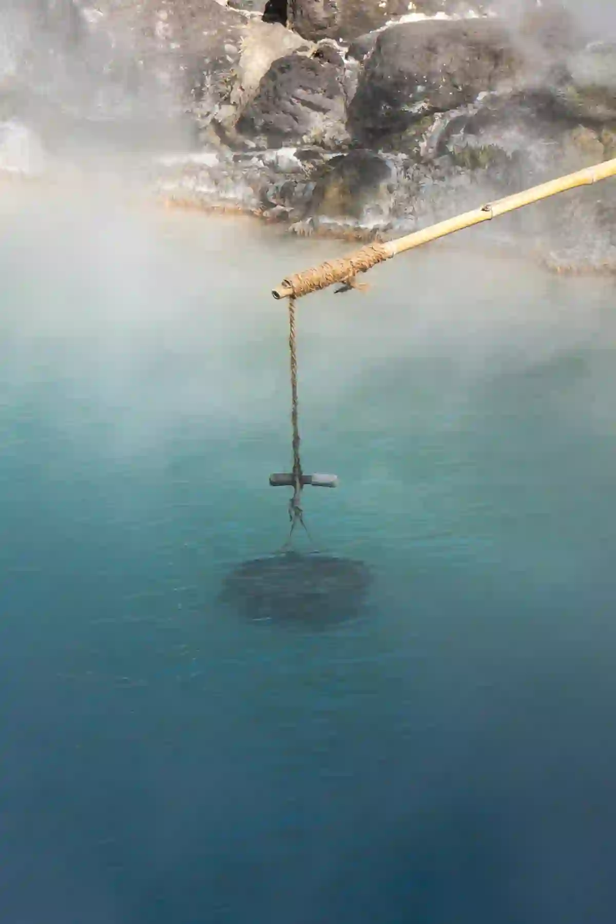 Steamy blue onsen bath water with wooden bath implements